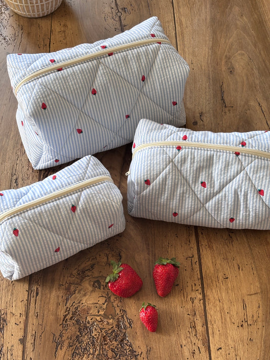 Trio of blue striped and strawberry beauty bags